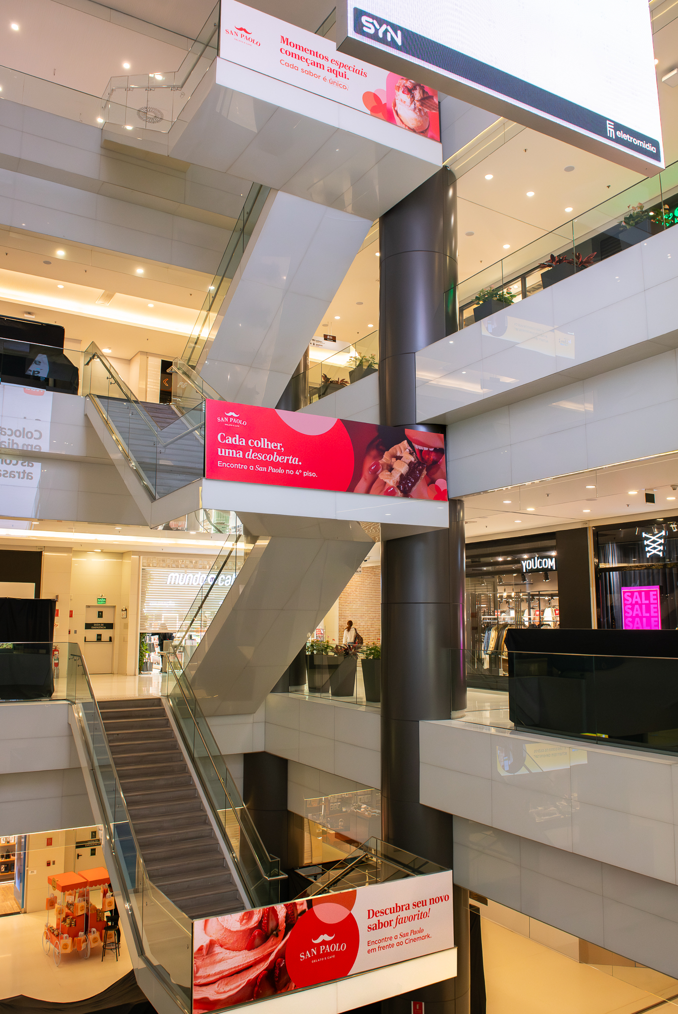 Mídia indoor em bandeiras e painéis de escada rolante de shopping com campanha San Paolo Gelato e Café