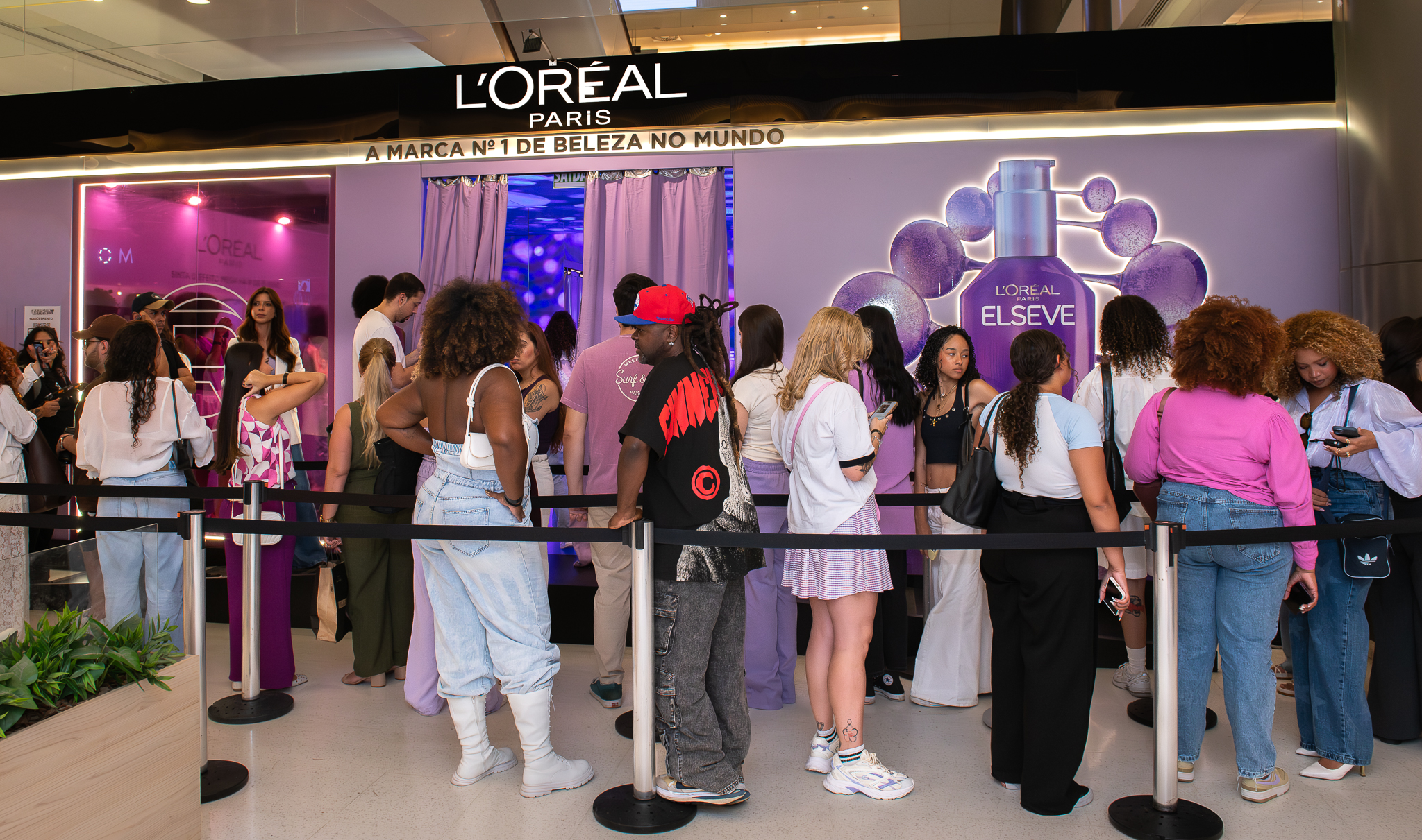 Fila de consumidoras aguardando entrada na loja pop-up da L'Oréal Paris Elseve em shopping center.