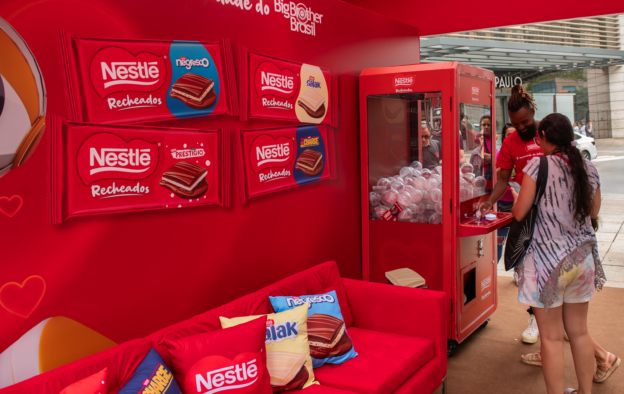 Consumidora interagindo com máquina de prêmios da Nestlé Recheados em ativação do Big Brother Brasil na Avenida Paulista